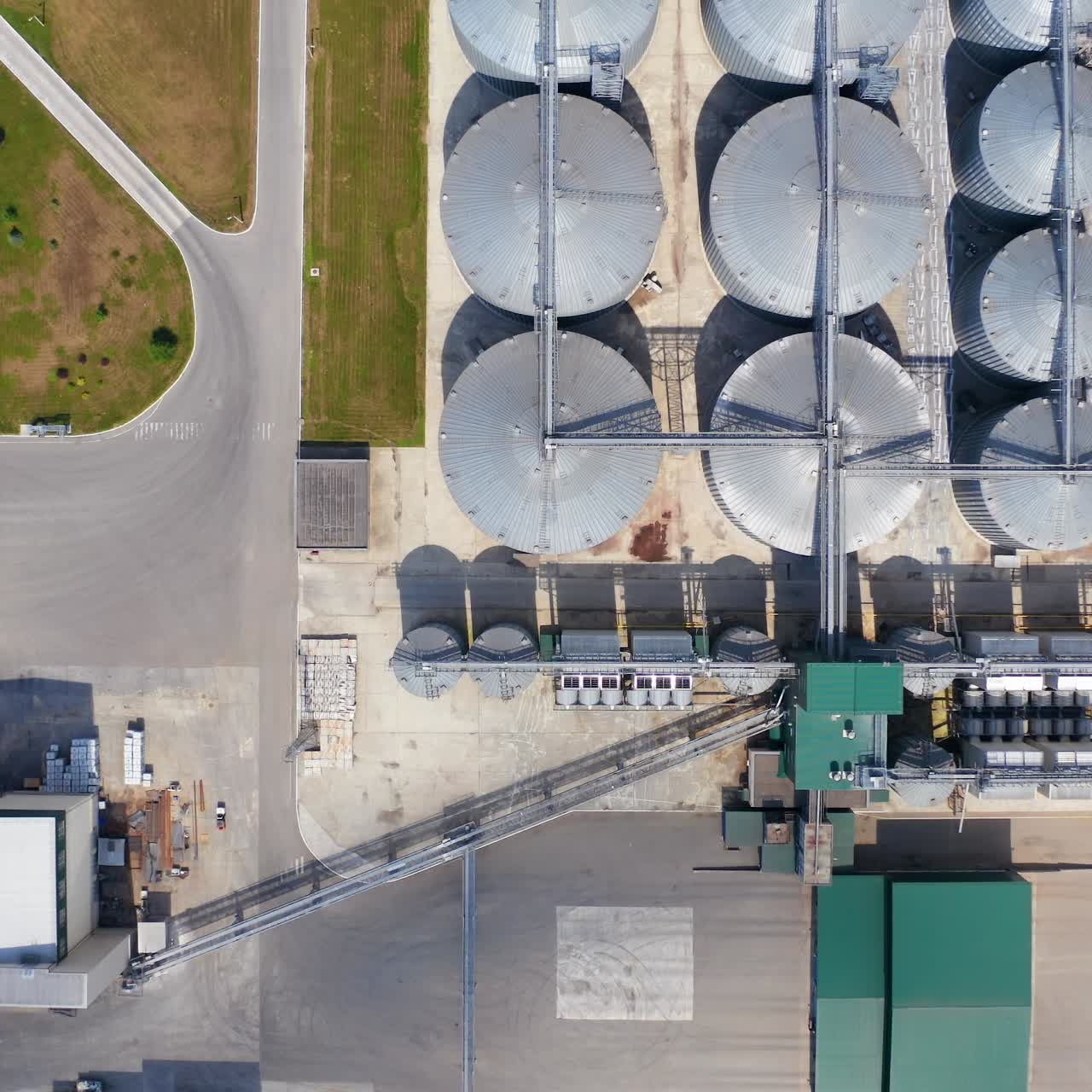 Plant for storage and processing of grain. Flight over silo system tanks. Metal grain bins on a modern agricultural factory. Aerial view