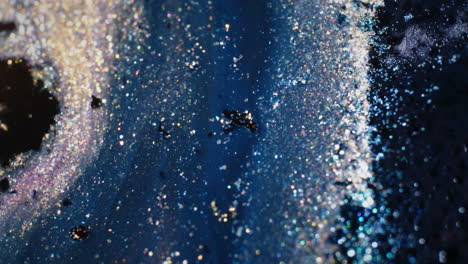 glittering particles in blue liquid create a shimmering abstract effect, macro close-up