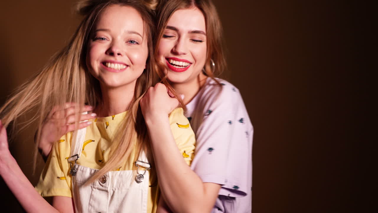 두 명의 행복한 젊은 여성들이 함께 포즈를 취하고 있습니다.