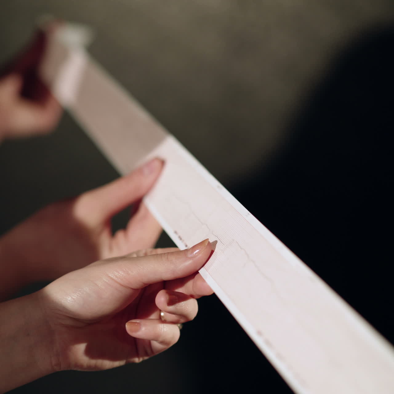 Electrocardiogram, ecg in hand, palm of a doctor. Clinic cardiology heart rhythm and pulse test closeup. Cardiogram printout.