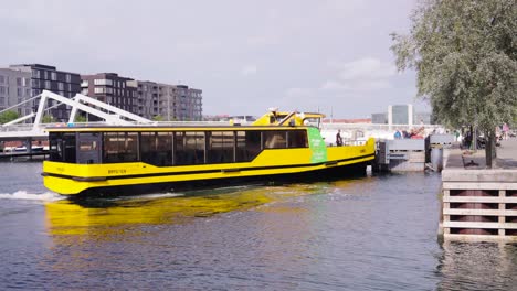 yellow water public transport boat leave dock in copenhagen, denmark