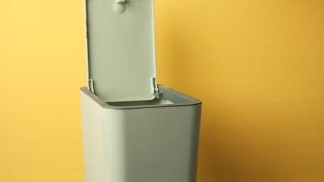 a person discards slices of bread into a trash can, demonstrating food waste
