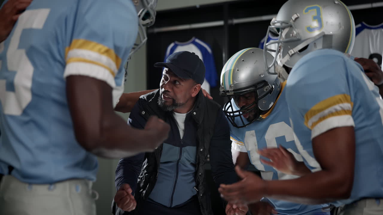 Squadra e allenatore di football nello spogliatoio