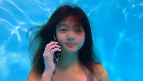 Young Woman Using Smartphone Underwater