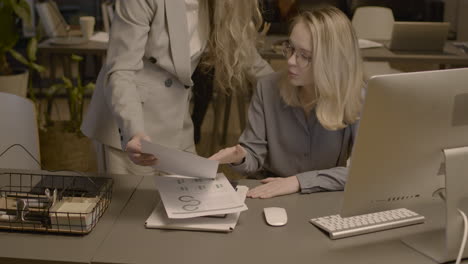 Two-Female-Employees-Talking-Together-And-Checking-Reports-In-The-Office-2