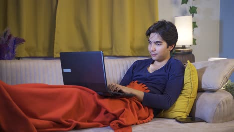 man lying down chatting facetime on laptop.