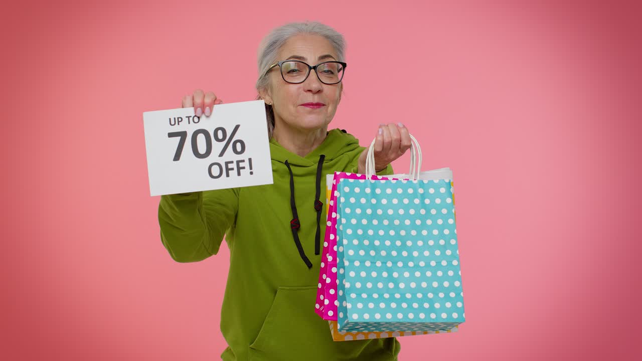 mujer feliz sosteniendo bolsas de compras y un cartel que dice hasta un 70% de descuento