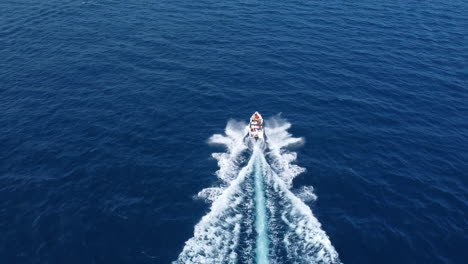 drone shot following pleasure yacht in the blue sea, high angle