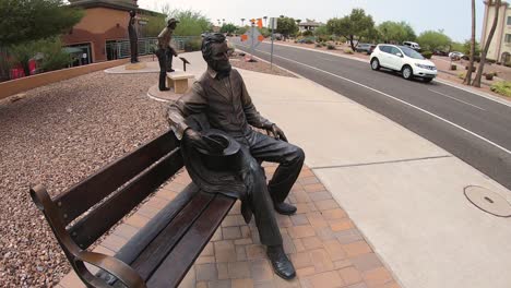 a bronze statue of president abraham lincoln sits on a park bench watching the traffic go by, fountain hills, arizona