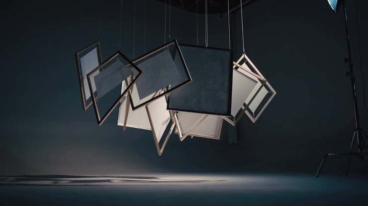Swinging frames with translucent inserts rotating on cables in studio, shadows moving for filming