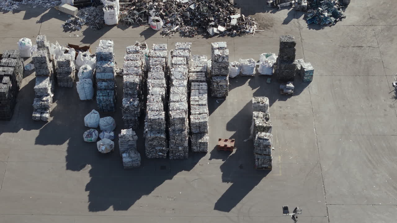Aerial view shows a recycling facility with various scrap metal bales organized in containers