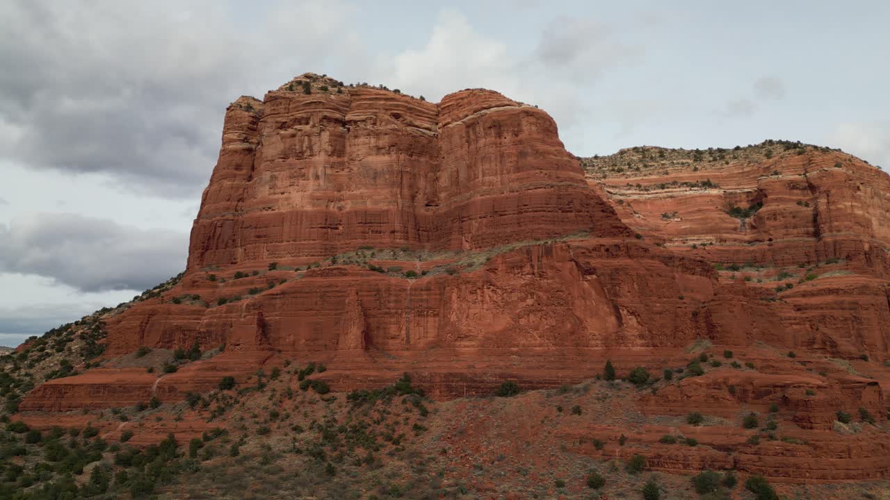 Aerial drone footage showcasing the stunning red rock formations of Sedona, Arizona, with dramatic cliffs, desert landscape, and scenic vistas under bright blue skies and warm sunlight