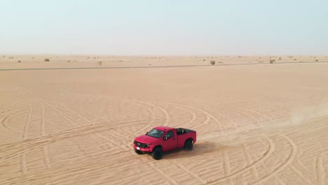 off-raod truck driving through the flat desert, drone track backwards