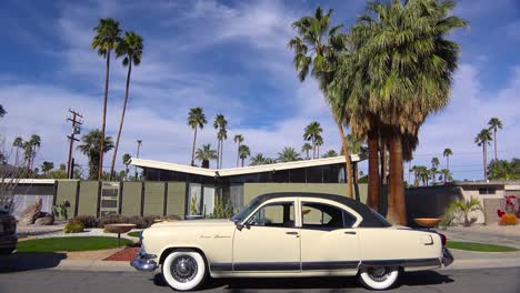 exterior establishing shot of a palm springs california mid century modern home with classic retro cars parked outside 2