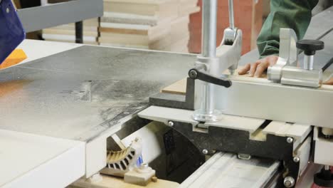 carpenter worker operating wood cutting machine