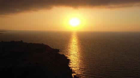 Drohnenschwenkaufnahme-Aus-Der-Luft-über-Die-Sonne,-Die-Morgens-über-Dem-Meer-Am-Horizont-Aufgeht