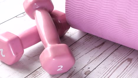 pink dumbbells and yoga mat