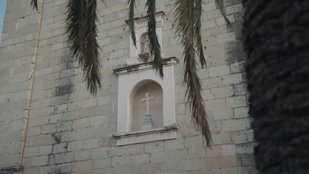Edificio in pietra con croce e statua