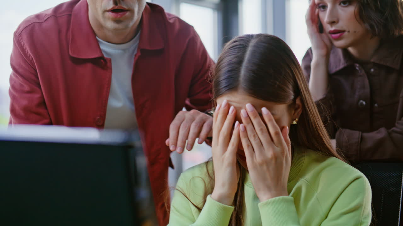 Primeros empleados de una startup con problemas en la oficina en primer plano. Compañeros de trabajo molestos mirando un portátil