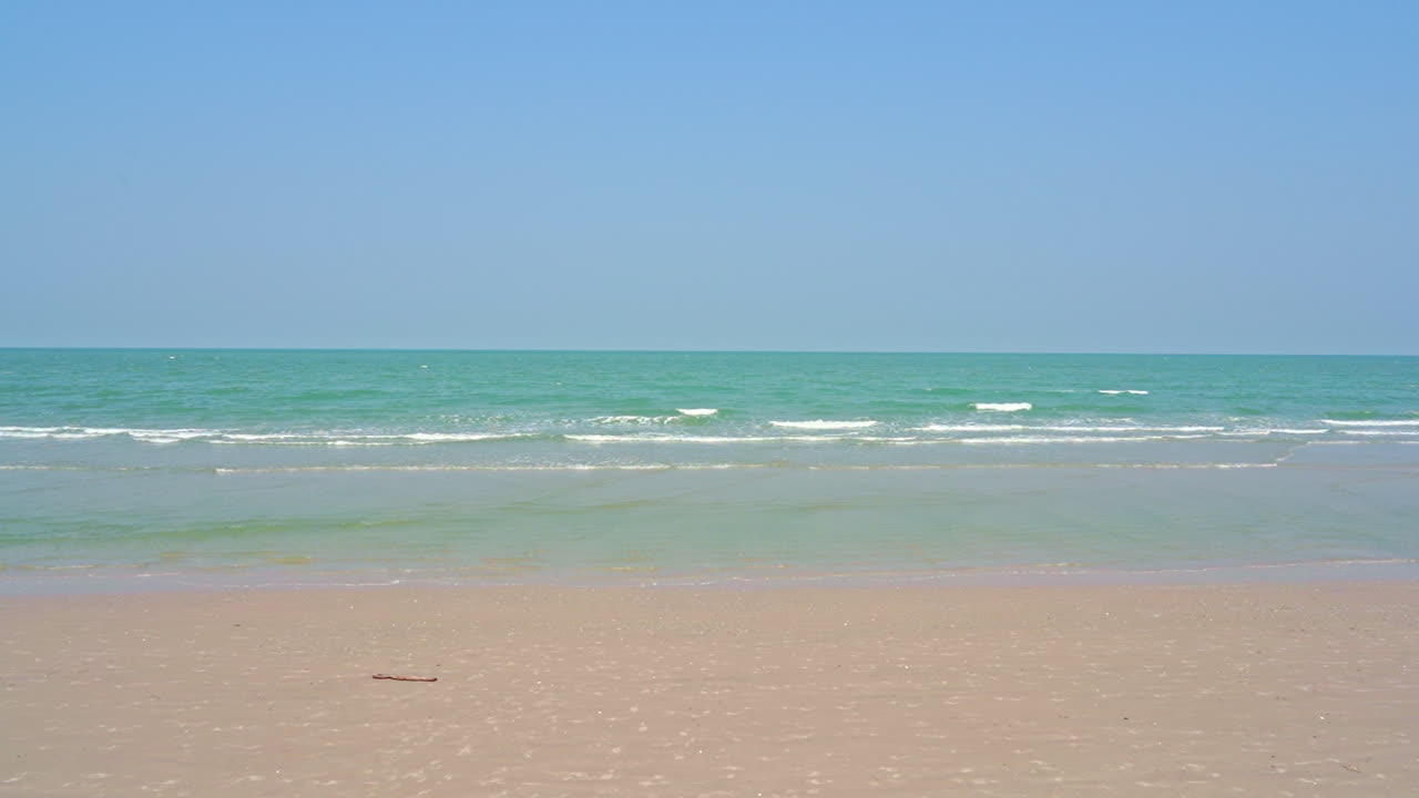 Tropical beach with deep blue sea and skyscape view. Soft waves on the beach