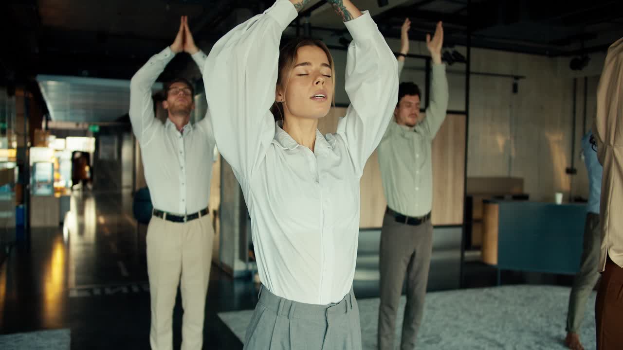 ⁇  셔츠 를 입은 금발 비즈니스 소녀 가 사무실 에서 동료 들 과 함께 요가 를 하고 있다. 영적 인 힘 과 안정 을 유지 하기 위해 일 에서 휴식 을 취하라