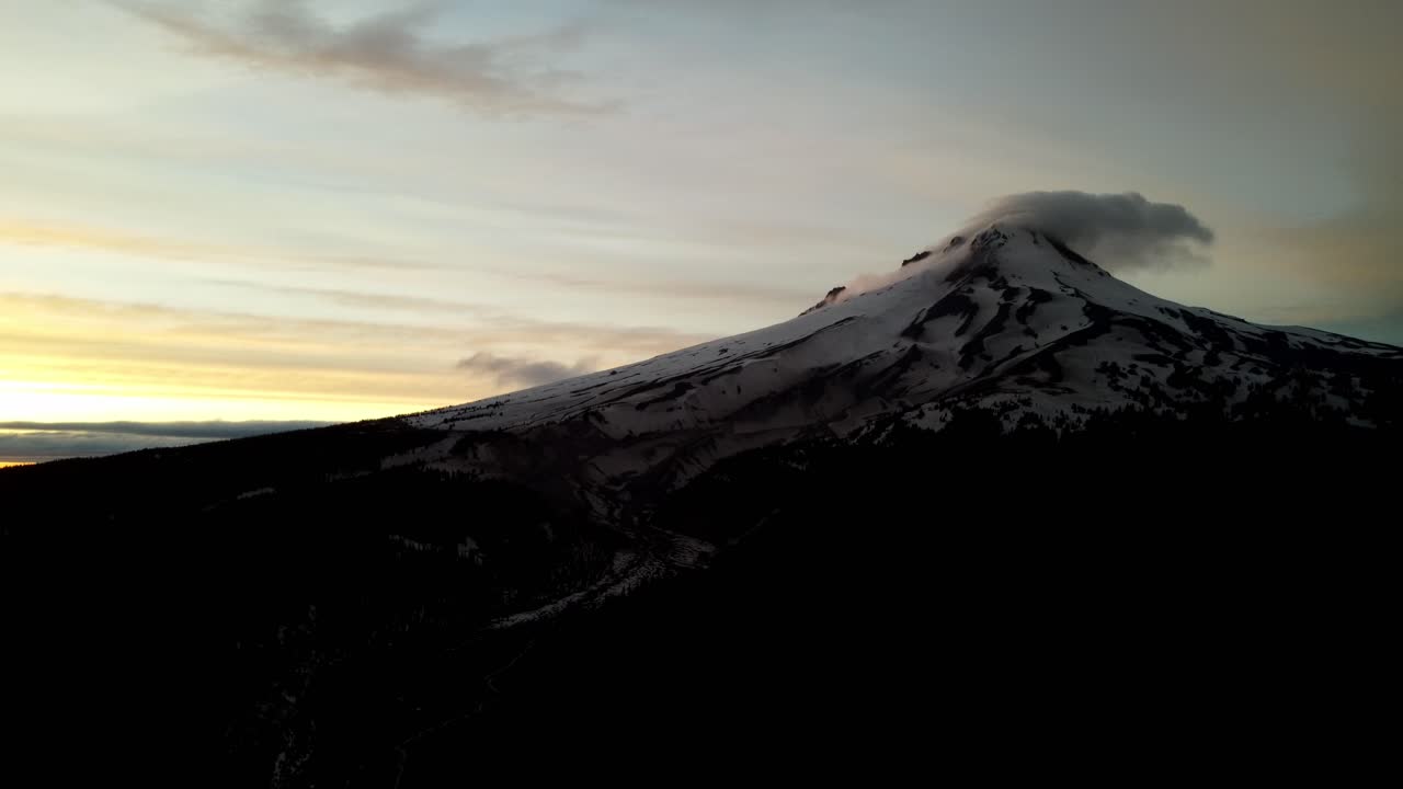 US, Oregon, Mt Hood, , 2025-05-10 - Drone view of Mt Hood in northern Oregon at sunset with clouds curling over the peak of the mountain in the Spring.