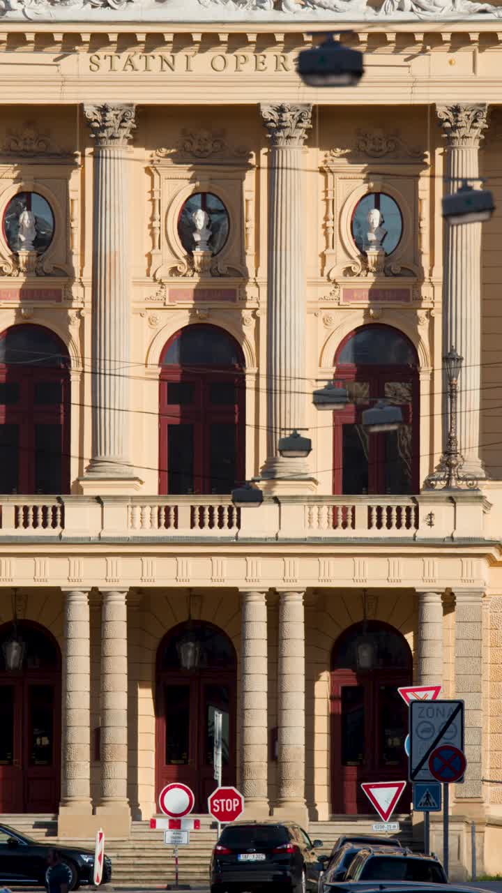 Veicoli passano davanti allo storico edificio dell'opera neoclassica a Praga, in pieno giorno, telecamera fissa