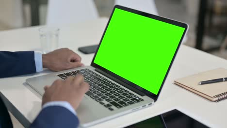 hombre de negocios usando una computadora portátil con pantalla clave de croma verde