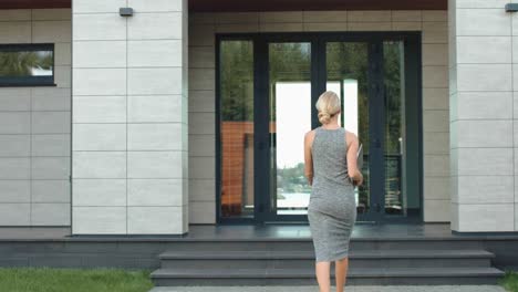 Mujer-De-Negocios-Entrando-Por-La-Puerta-De-La-Oficina-De-Lujo-Con-Computadora.