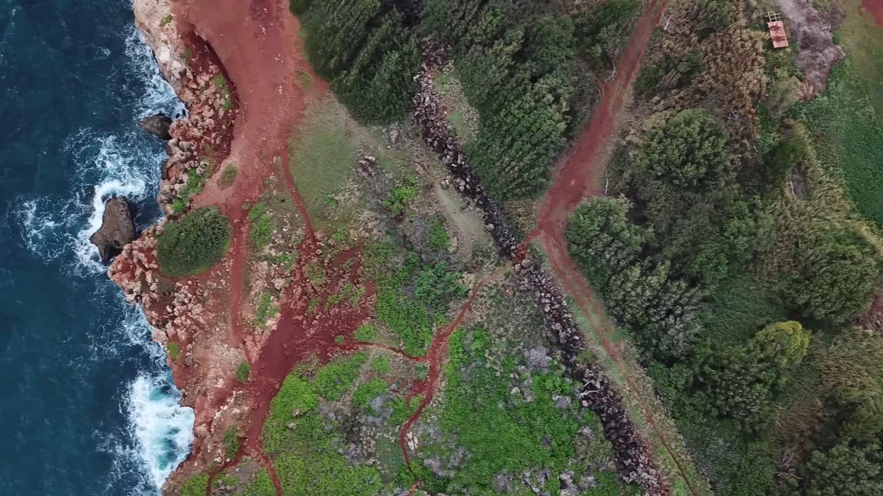 paneo de drones a la izquierda sobre la antigua pared de roca, camino de tierra y acantilados oceánicos en el océano en kauai, hawaii