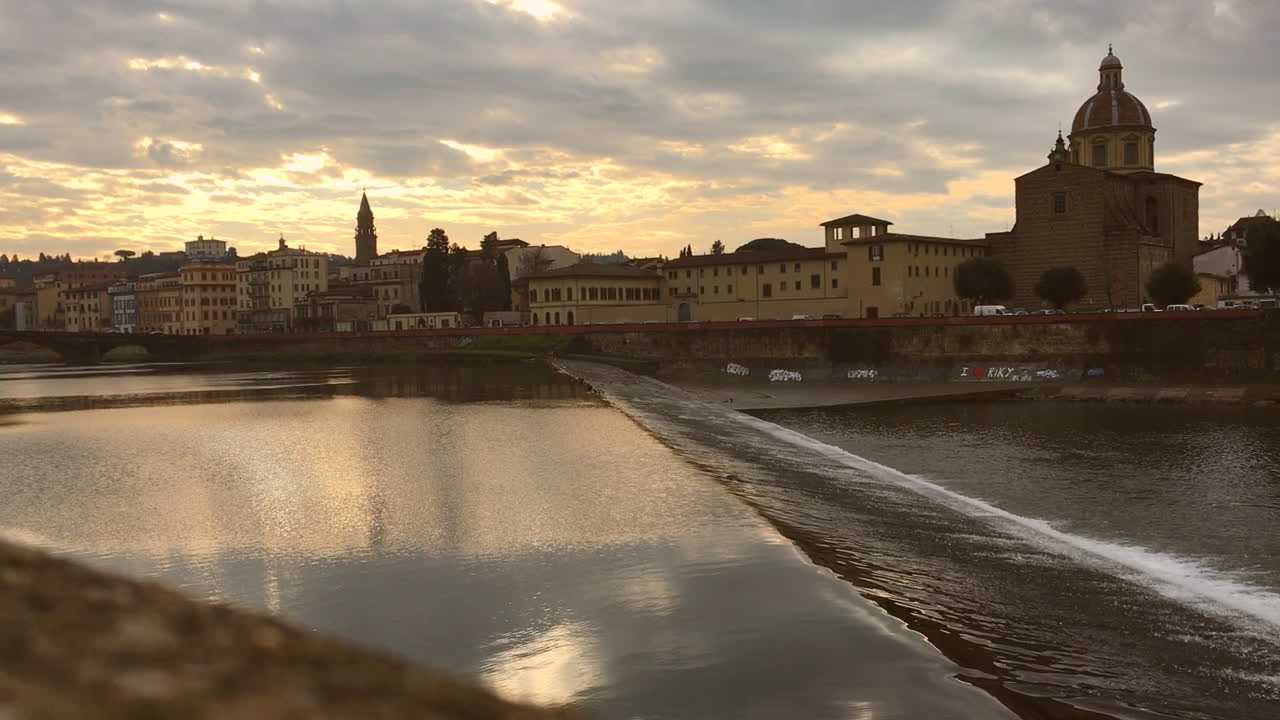 Arno River flowing through Florence, Italy, at sunset
