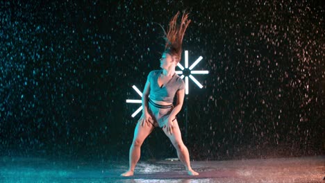 woman dancer spinning wet hair in the rain in super slow motion