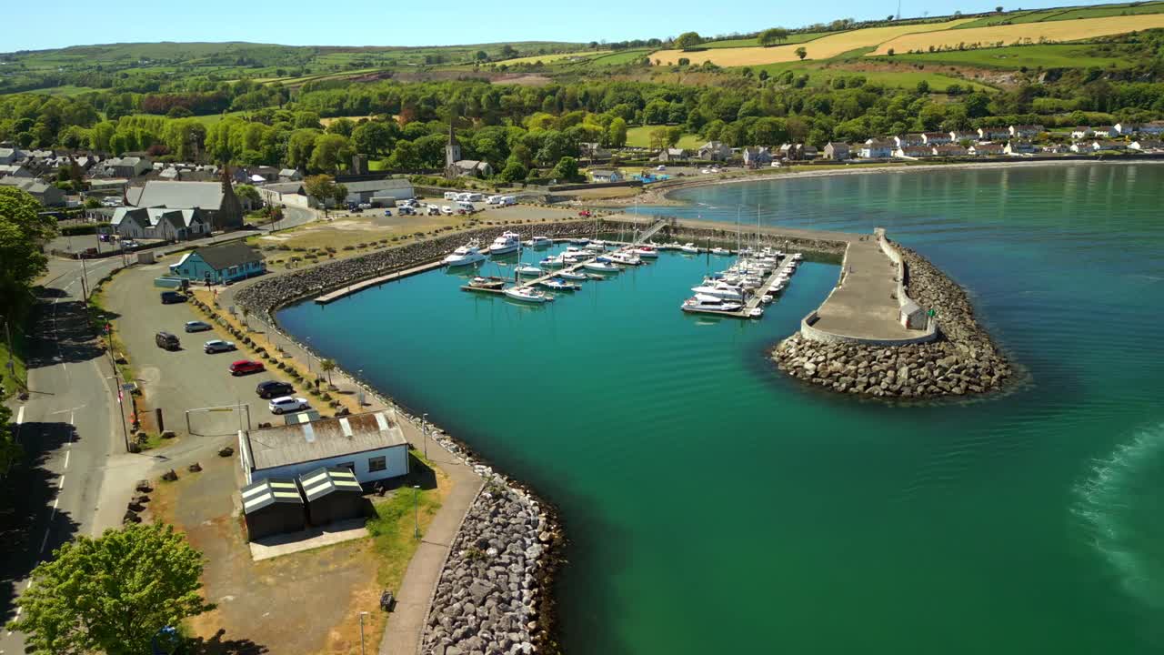 Advancing aerial video of Glenarm Bay, on the Causeway Coastal Route in Northern Ireland, on a bright and sunny day. Filmed in 4K, 60FPS and with Rec709 color.