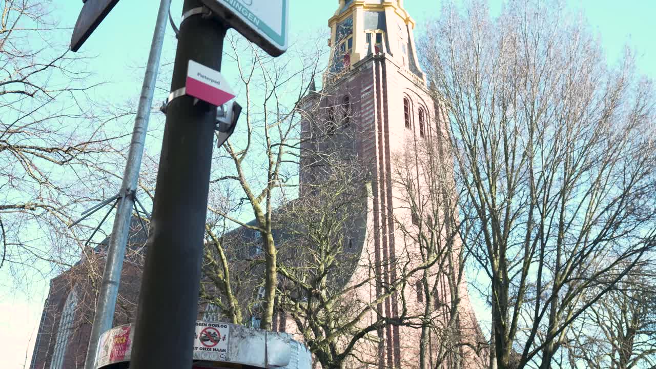 Storica torre campanaria e alberi spogli nella città di Groningen