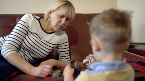 grandmother and granson playing with toys on the sofa