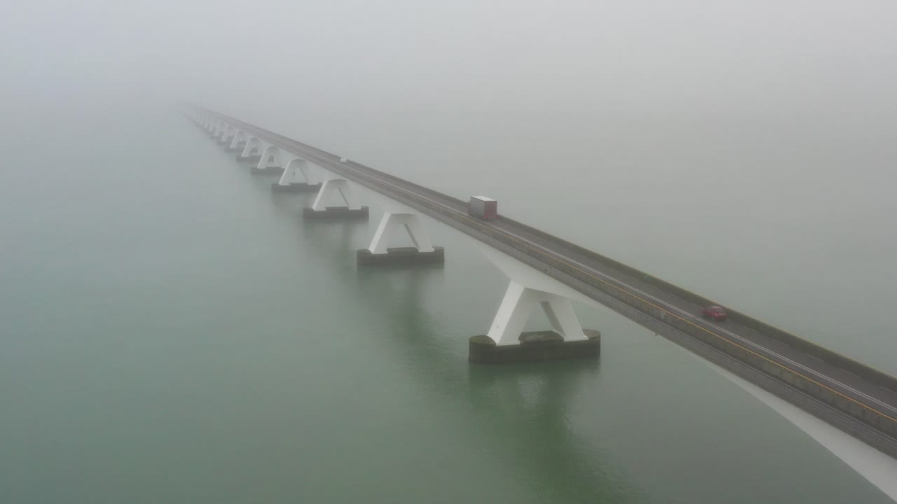 Traffic crossing the Zeeland bridge during fog. Drone shot