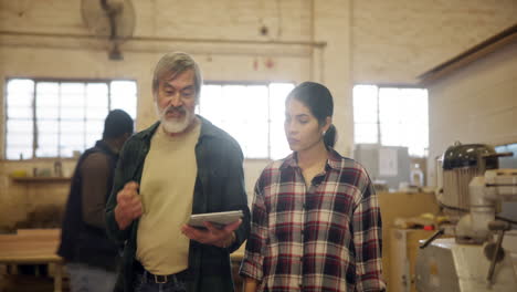 carpenters discussing project in woodworking shop