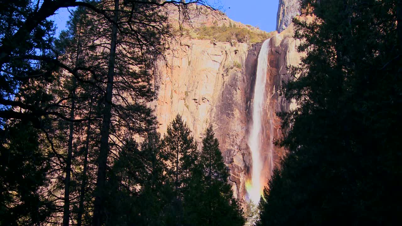 una hermosa cascada en el parque nacional de yosemite proyecta un arco iris