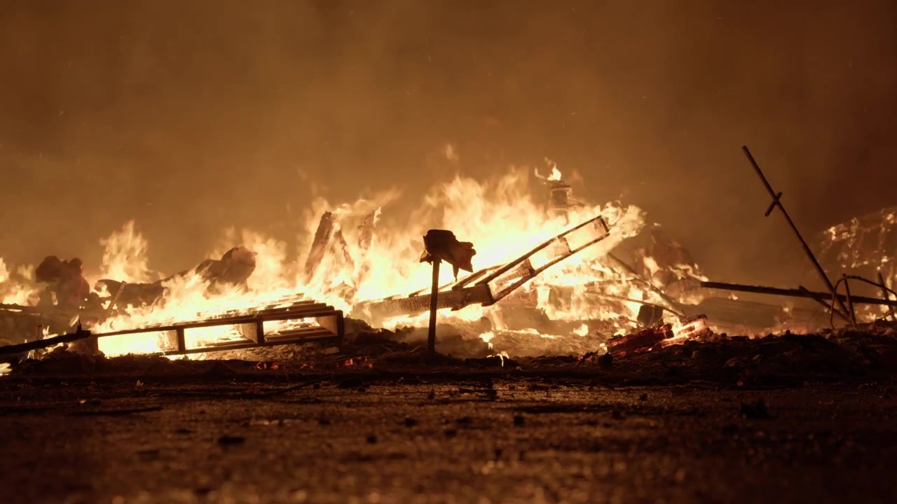 Vista a livello del suolo dei rottami della falla che bruciano durante la cremà de Las Fallas