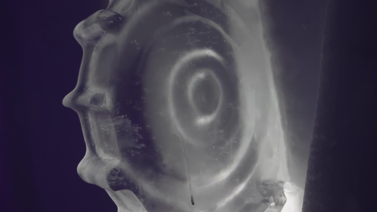 Grande ingranaggio decorativo scolpito nel ghiaccio in una stanza poco illuminata