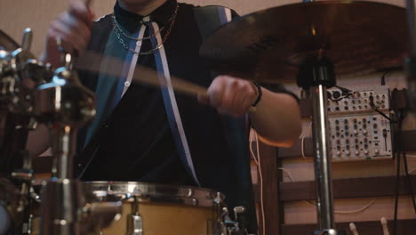 male musician playing drums during a band rehearsal in recording studio 1