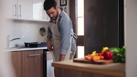 hombre preparando comida y limpiando en la cocina