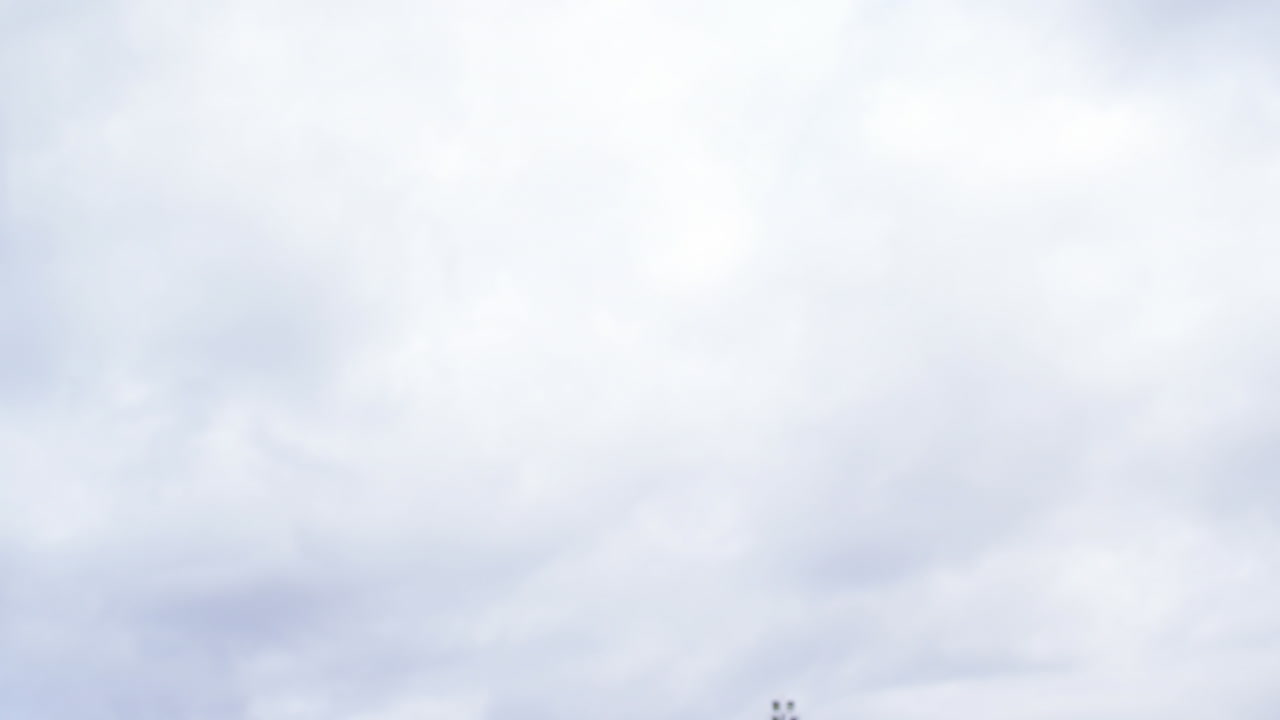 알림 바의 애니메이션, 백인 축구 선수가 구름이 가득한 하늘을 향해 머리로 공을 때립니다.