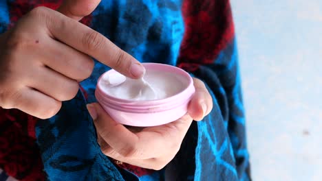 mujer aplicando crema facial