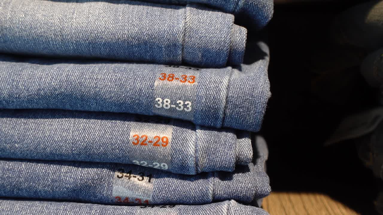 Stack of Folded Blue Jeans with Size Labels