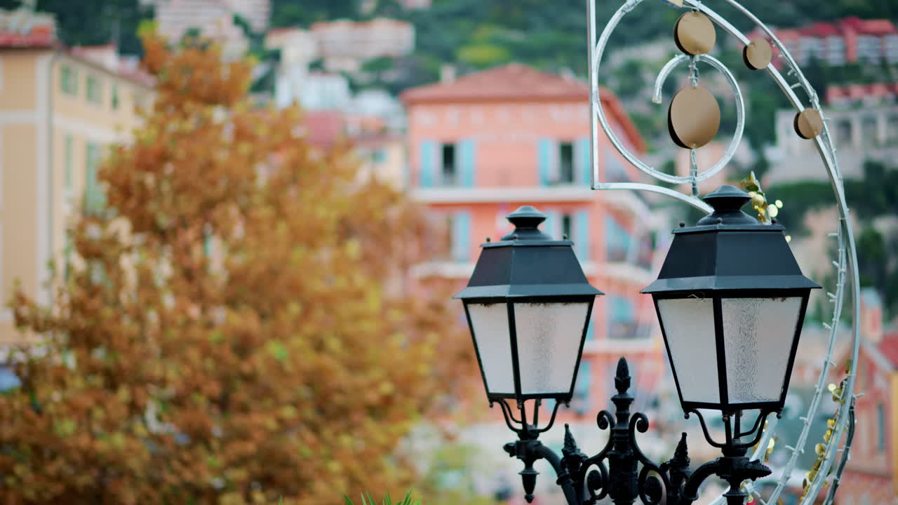 Close up of a street lamp with a blurry city view on the background