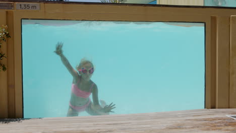 young girl swimming in a transparent pool