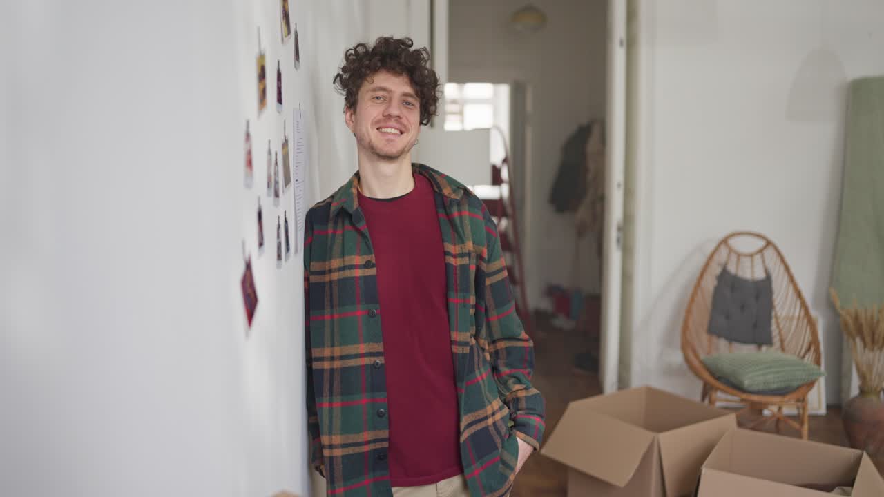 Young man smiling while moving into a new home