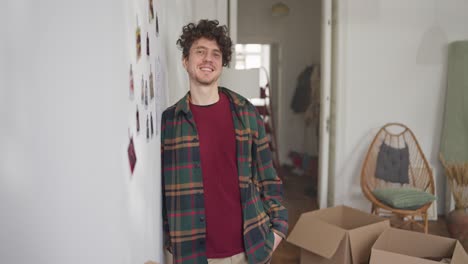 young man smiling while moving into a new home
