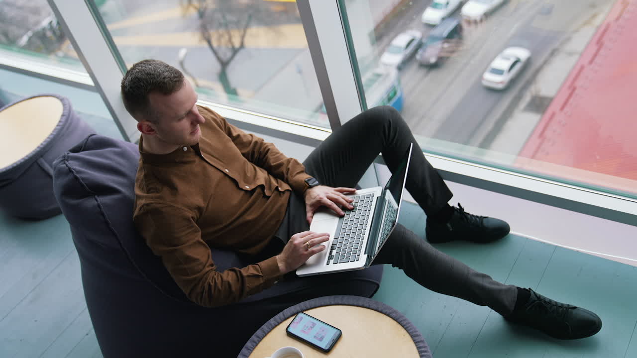 Attractive man using laptop in co-working space.